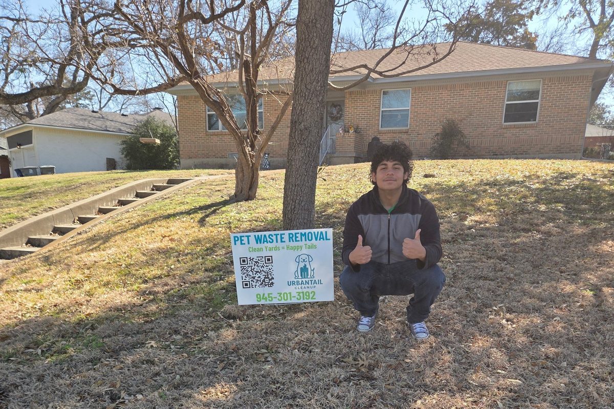 UrbanTail Cleanup technician next to a pet waste removal yard sign at an East Dallas home