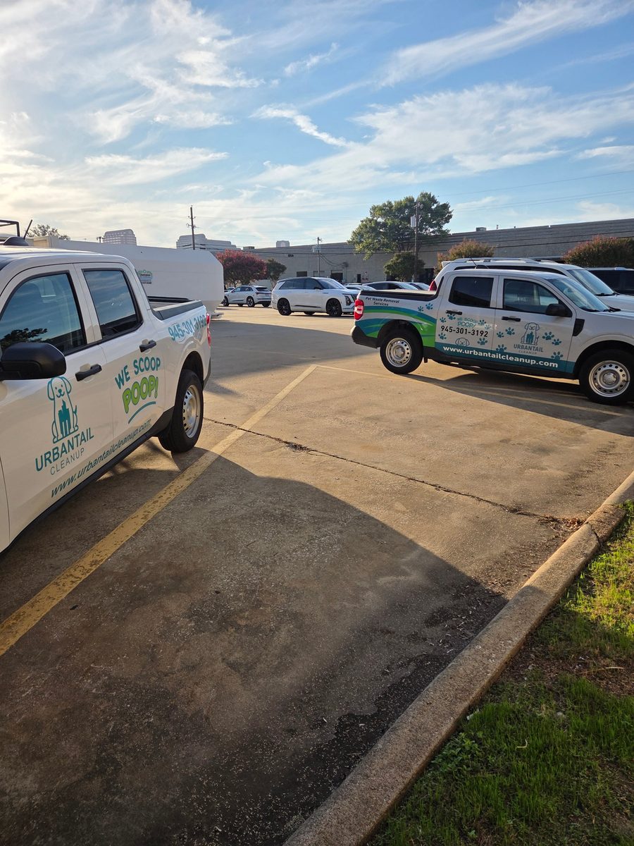 Two UrbanTail Cleanup pet waste removal trucks with branded wraps